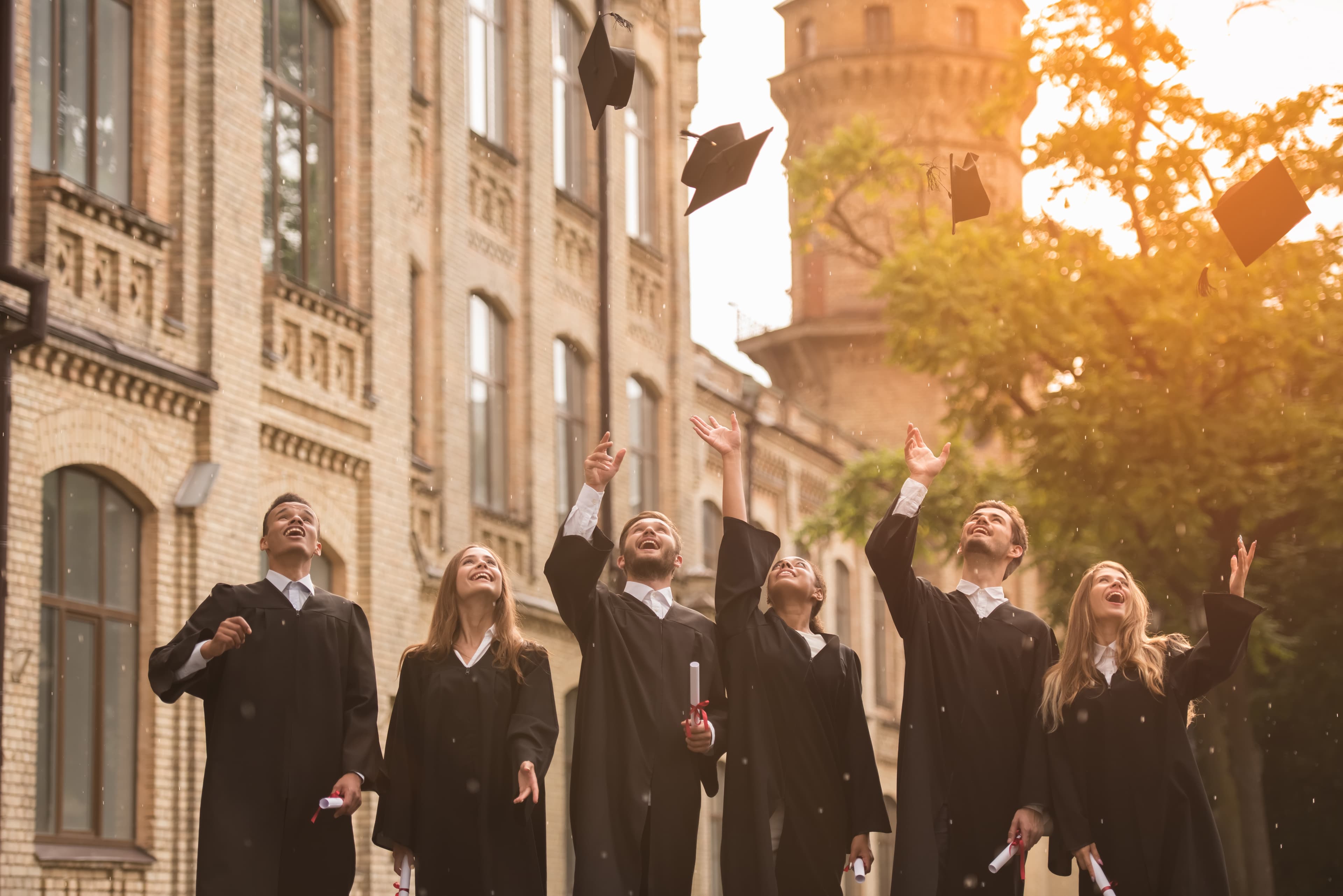 Many students jumping with graduation gown