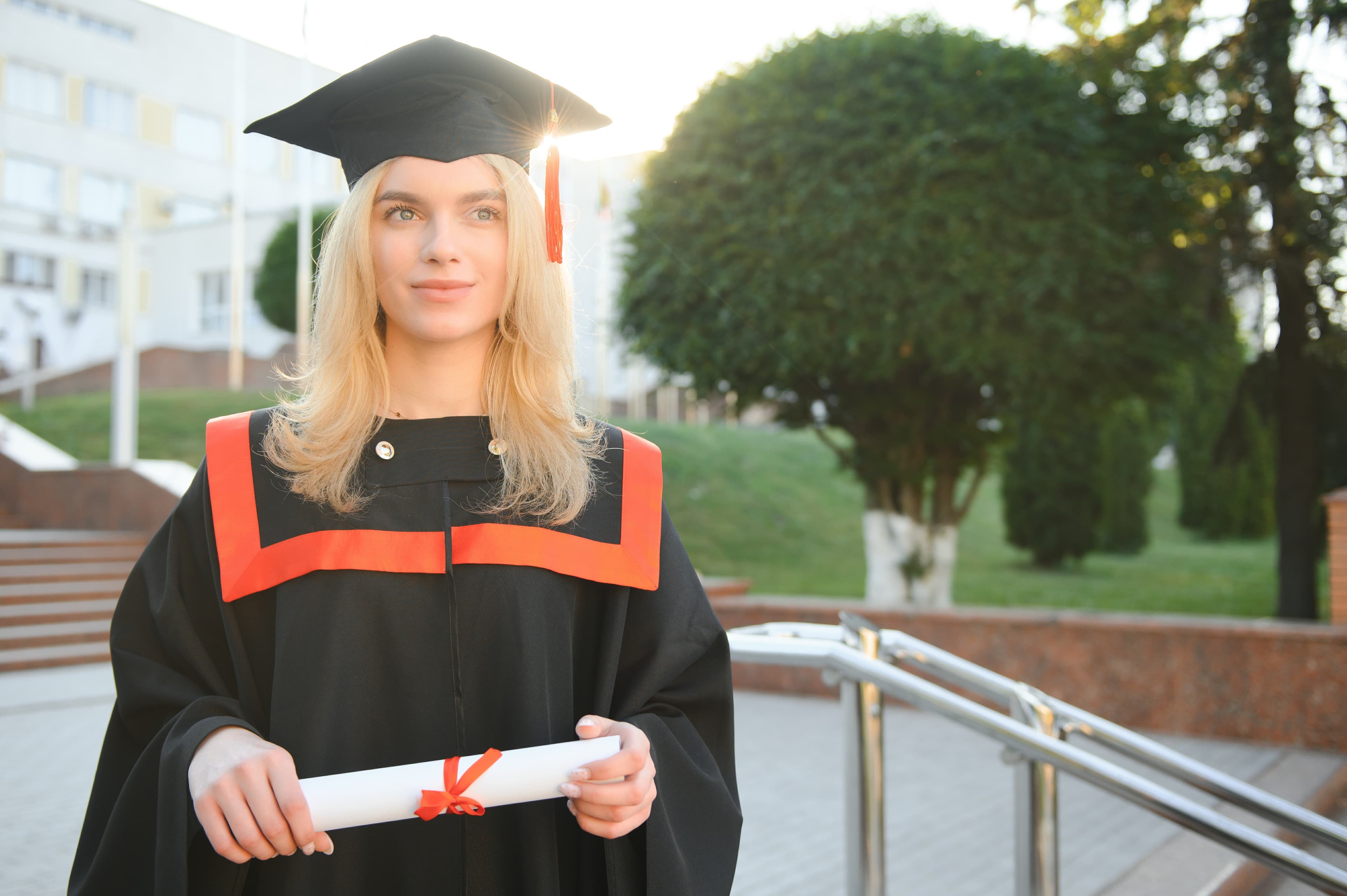 Blonde lady with black graduation gown half shoulders turned